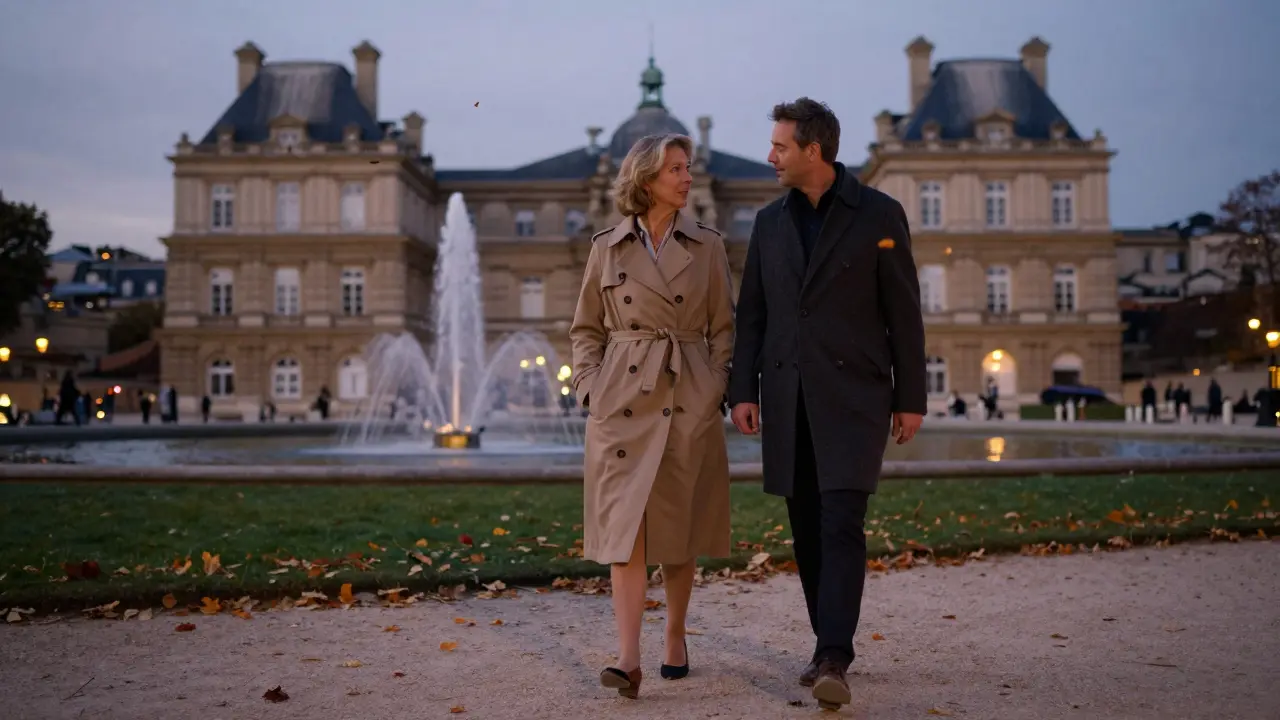 A man and woman walk peacefully through Luxembourg Gardens at dusk, engaged in quiet conversation.